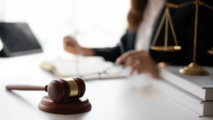 Lawyer working at their desk, which has books, gavel, and books on it